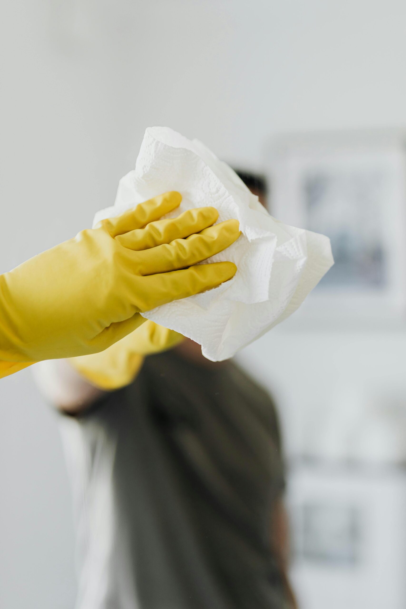 Cleaner wiping a glass surface during service preparation